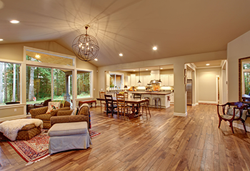 Luxury open-concept living space in Beverly Hills with orbital chandelier and forest views